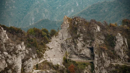 Cyclists on a mountain forest path with rocks and caves