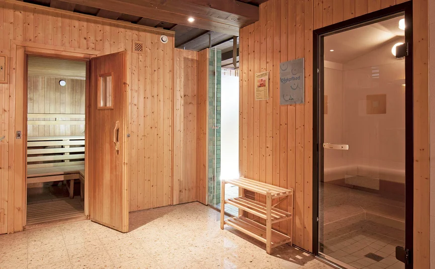 Saunaruimte met houten wanden, bank en stoomcabine