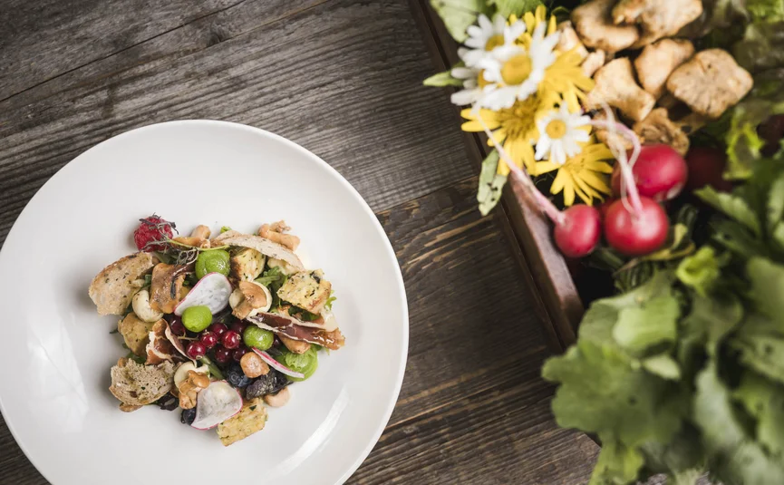 Salad and vegetable snack on white plate on wooden table