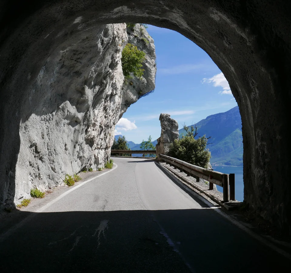 Unterwegs auf der Bond-Straße © Tobias Köhler Bergstraße mit Tunnelöffnung und Blick auf See und Berge