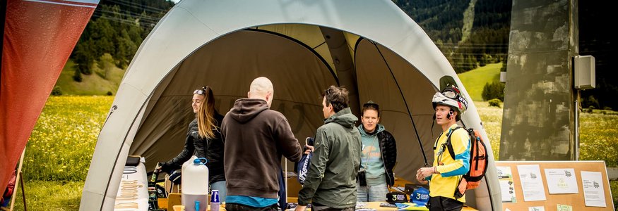 Green Days in Nauders-Reschensee © Anne Kaiser Photography Menschen am Informationsstand mit Zelt in ländlicher Umgebung