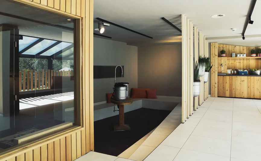 Moderner Wellnessbereich mit Holzakzenten und Sitzbereich mit Kissen