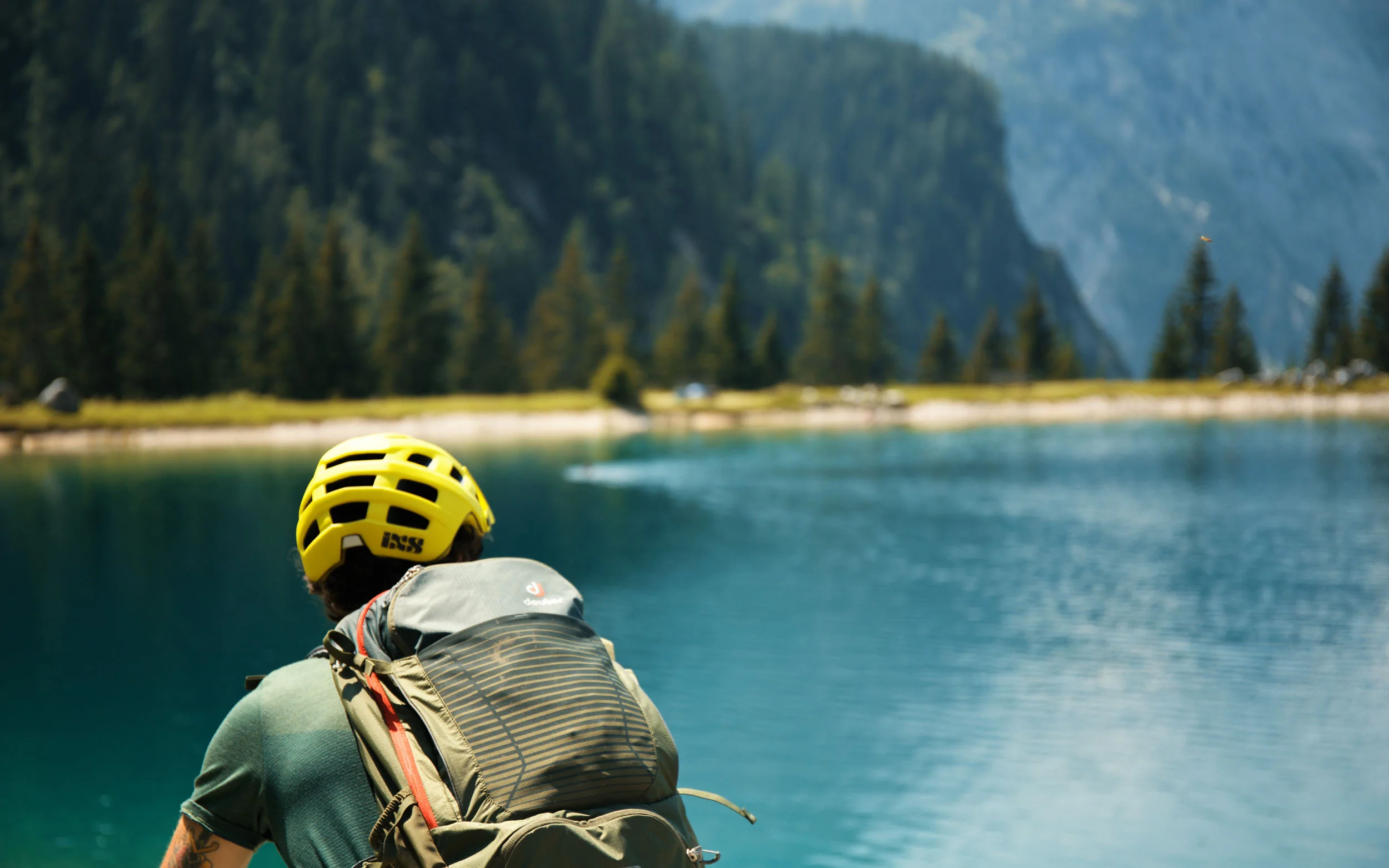 Mountainbiker mit gelbem Helm an einem Bergsee