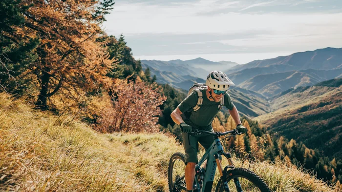 #Uphillflow – der Spaß beginnt schon bergauf © Bosch eBike Systems Mountainbiker fährt auf einem herbstlichen Bergpfad mit Bergpanorama