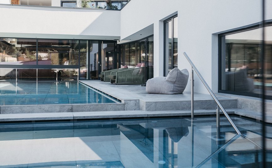 Outdoor Pool Hotel Rupertus © Heldentheater Modern indoor pool with glass walls and comfortable seating