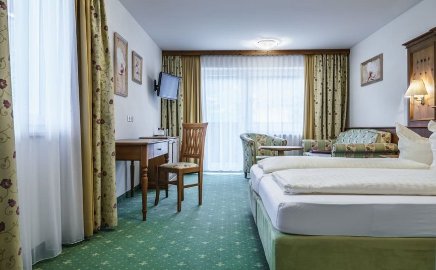 Cozy hotel room with double bed, desk, chair, and seating area