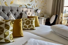 Knusse tweepersoonskamer met decoratieve kussens en helder natuurlijk licht