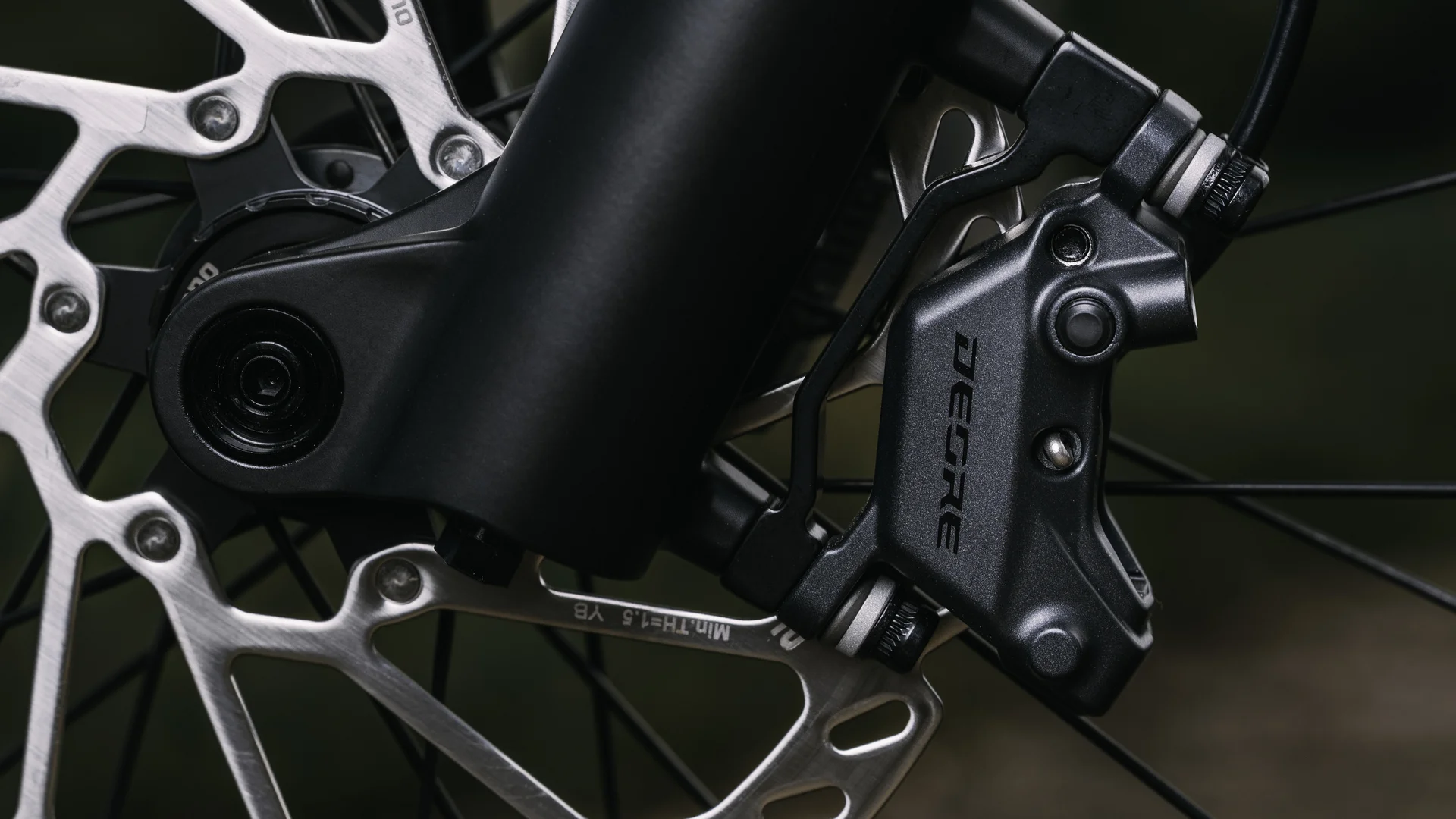 Nahaufnahme einer Fahrradscheibenbremse mit silberner Bremsscheibe und schwarzem DEORE-Bremssattel