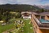 Hotel mit Pool auf Balkon und grüner Berglandschaft im Hintergrund