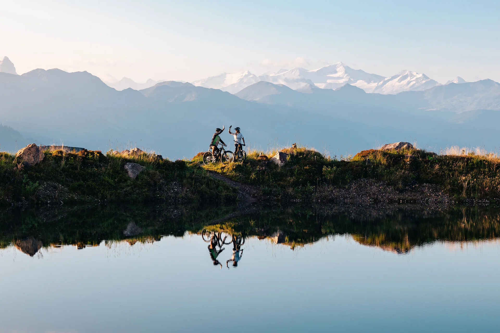 Zwei Mountainbiker feiern mit Bergblick am Seeufer