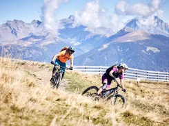 Zwei Mountainbiker fahren im Gebirge auf einem Pfad entlang
