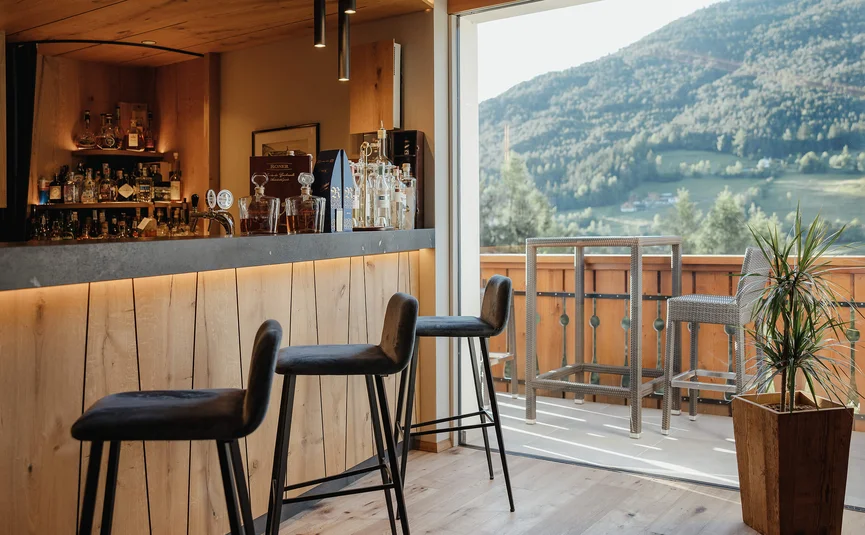 Moderne bar met krukken en uitzicht op bergen vanaf balkon