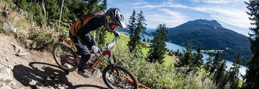 GREEN DAYS 2026 in Nauders-Reschensee
© Manfred Stromberg Mountainbiker fährt auf felsigem Waldweg mit Berg und See im Hintergrund