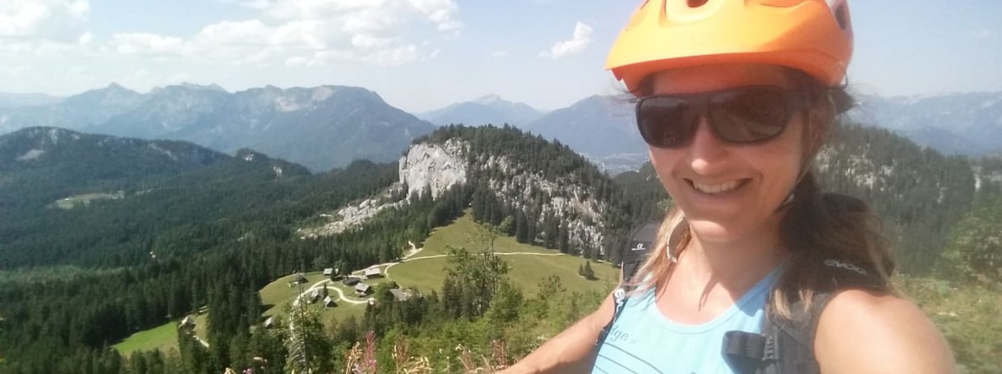 Berge-Seen-E-Bike-Package Vrouw met helm en zonnebril maakt selfie in zomerse bergen