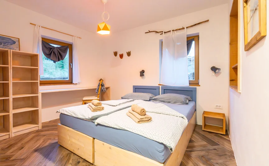 Gezellige slaapkamer met twee eenpersoonsbedden en houten decoratie.