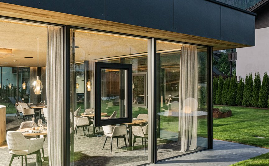 Modern glazen gebouw met uitzicht op bergen en zitgedeelte binnen