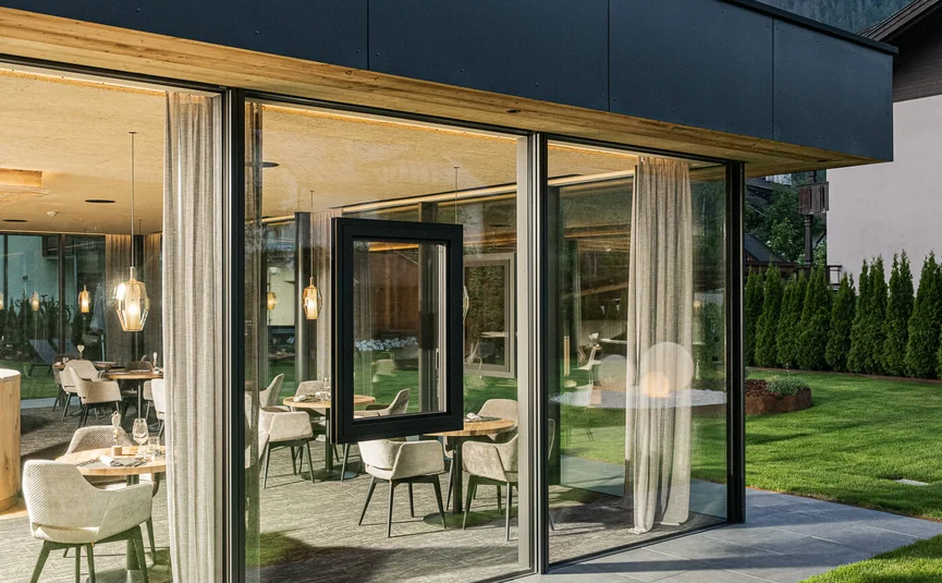 Modern glazen gebouw met uitzicht op bergen en zitgedeelte binnen