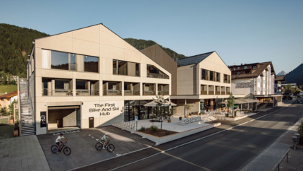 Modern gebouw met fiets- en skihub en twee fietsers buiten