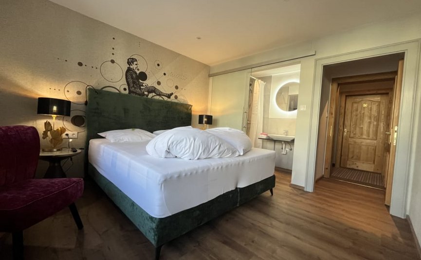 Gemütliches Hotelzimmer mit Doppelbett und Waldblick