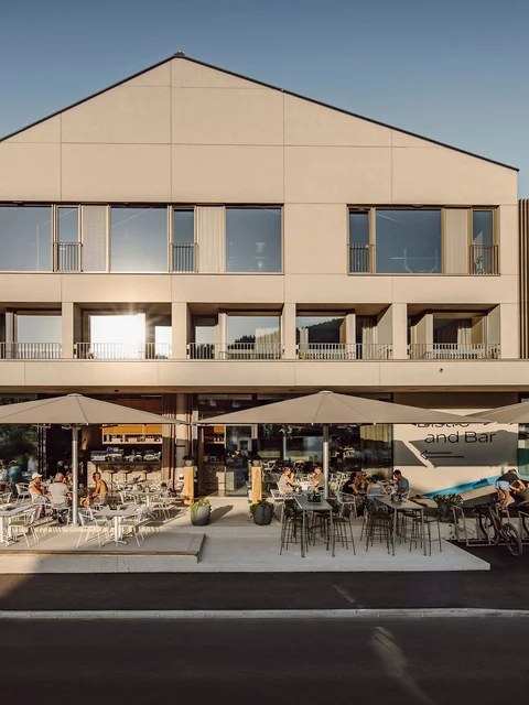 Außenansicht von Dips & Drops Bistro mit Terrasse und Gästen bei Sonnenlicht