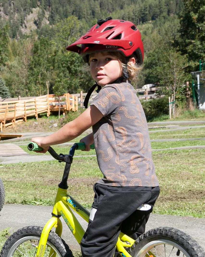 Kinder fahren Fahrrad auf einem Mountainbike-Pfad in bergiger Landschaft