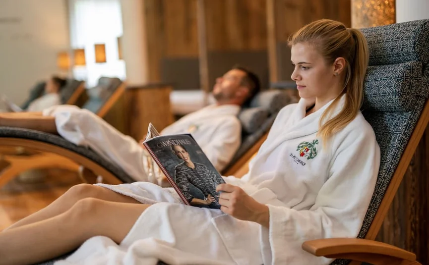 Woman in a bathrobe reading a magazine in a reclining chair