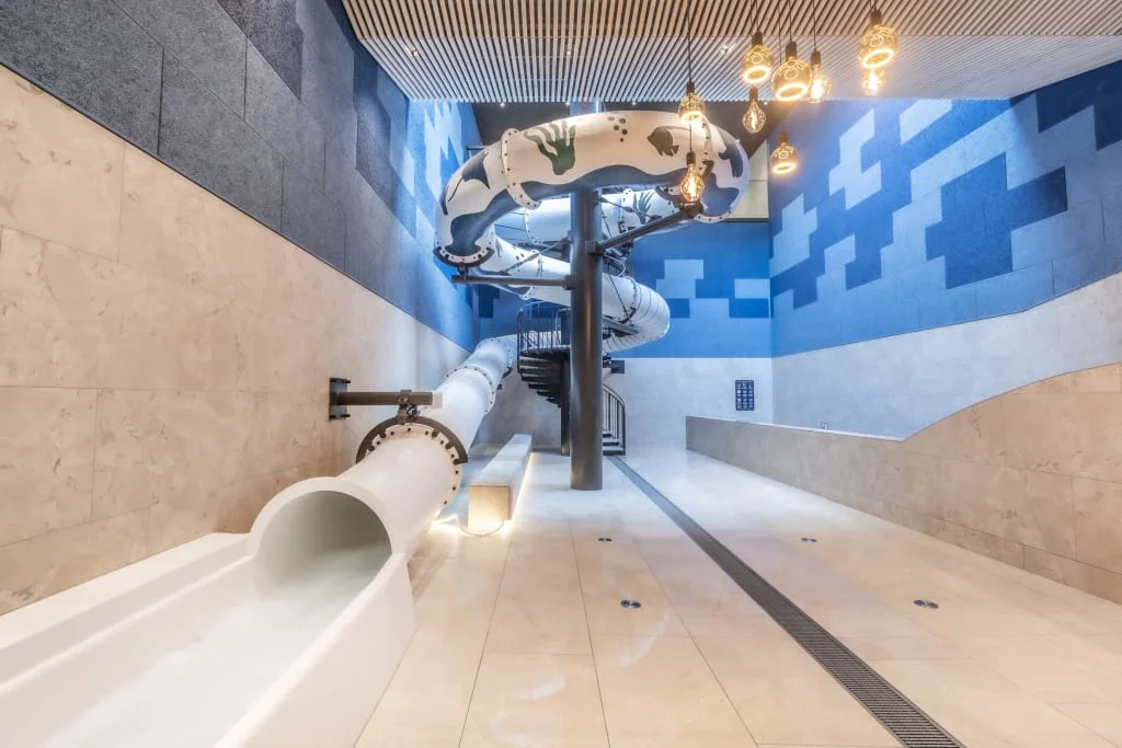 Moderne Indoor-Rutsche in einem blauen und beigen Raum mit Spiraltreppe