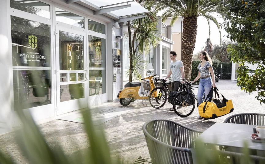Couple with bike and bag outside Aktivhotel Santa Lucia entrance
