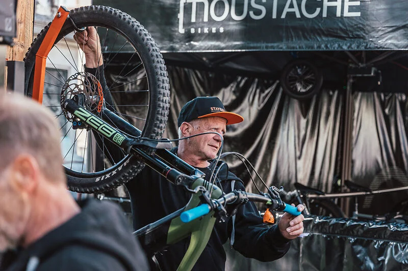 Das war die bike festa Südtirol in Brixen © Brixen Tourismus-FilmIT Mann trägt Mountainbike auf Schulter vor Moustache Bikes Stand