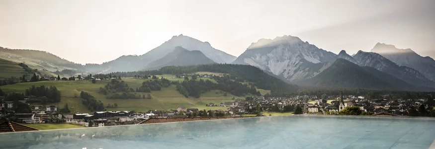 Mountain landscape with villages and lake, mountains reflected in water