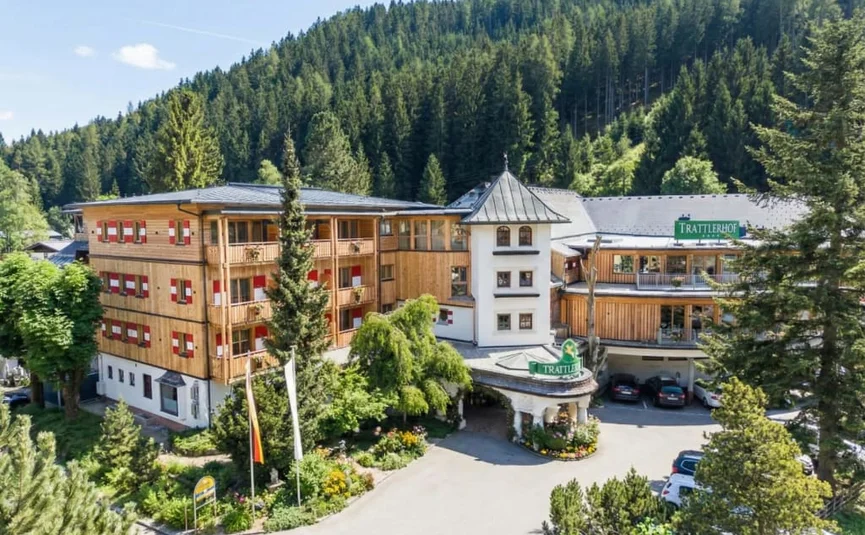 Wooden hotel in the mountains surrounded by green trees and clear sky