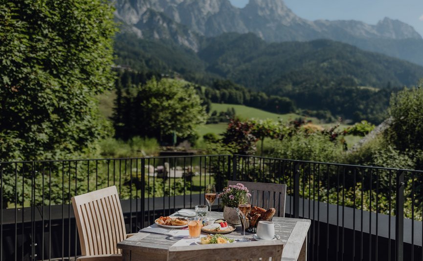 Puradies © Lukas Reschreiter Tisch mit Frühstück auf Balkon mit Bergblick und grünen Bäumen