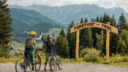 Zwei Mountainbiker feiern am Eingang des Forsthof Trails