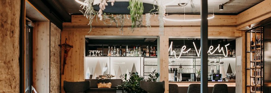 Moderne gemütliche Bar mit Pflanzen und runden Hängelampen