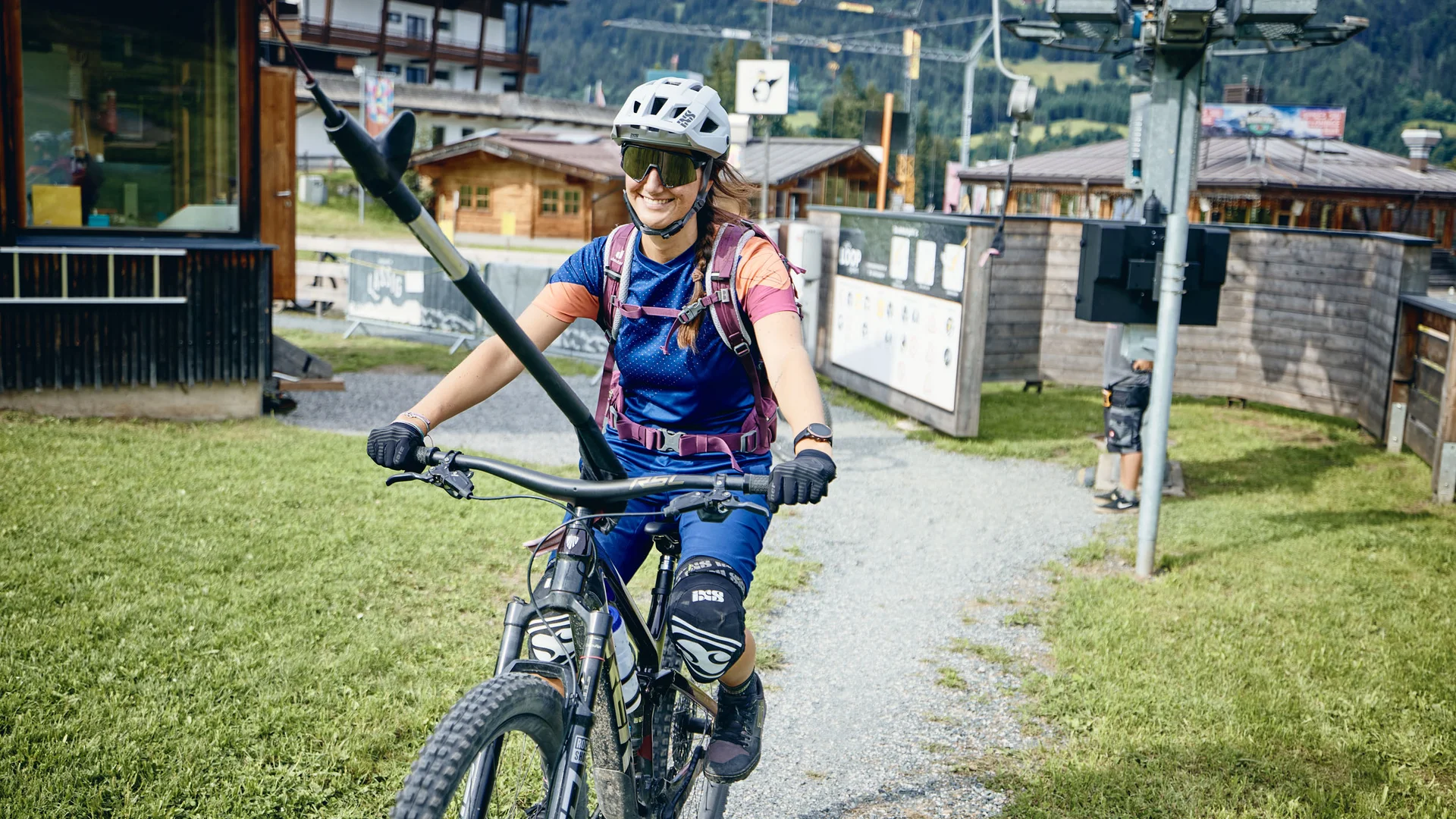 Frau mit Helm und Schutzkleidung auf Mountainbike in Berglandschaft