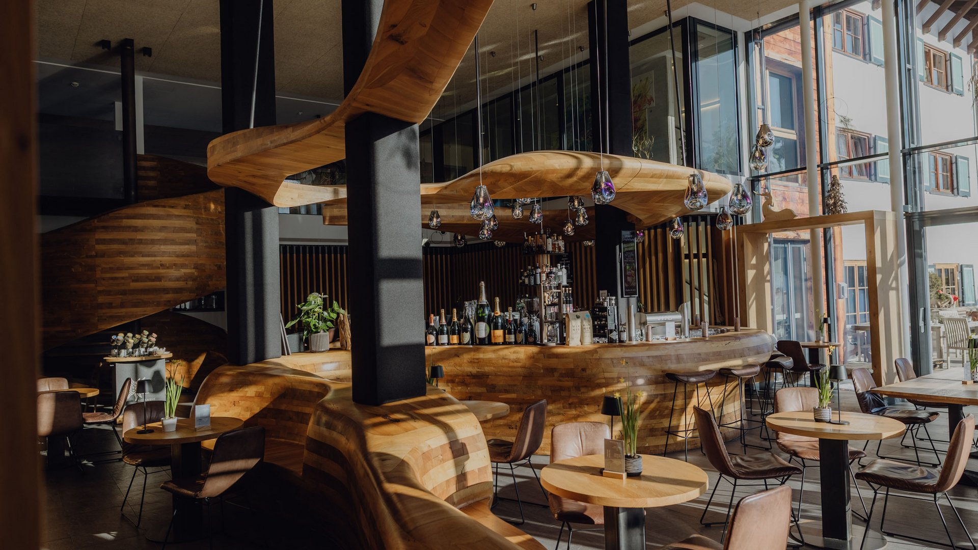 Moderne Bar mit geschwungenem Holzdesign und vielen Sitzplätzen
