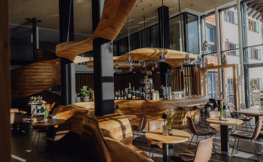 Moderne Bar mit geschwungenem Holzdesign und vielen Sitzplätzen