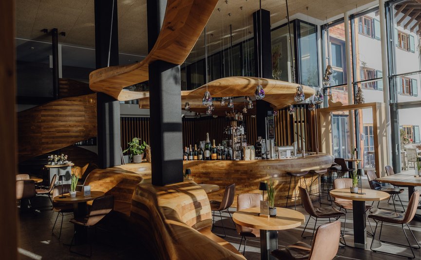 Puradies © Lukas Reschreiter Moderne Bar mit geschwungenem Holzdesign und vielen Sitzplätzen