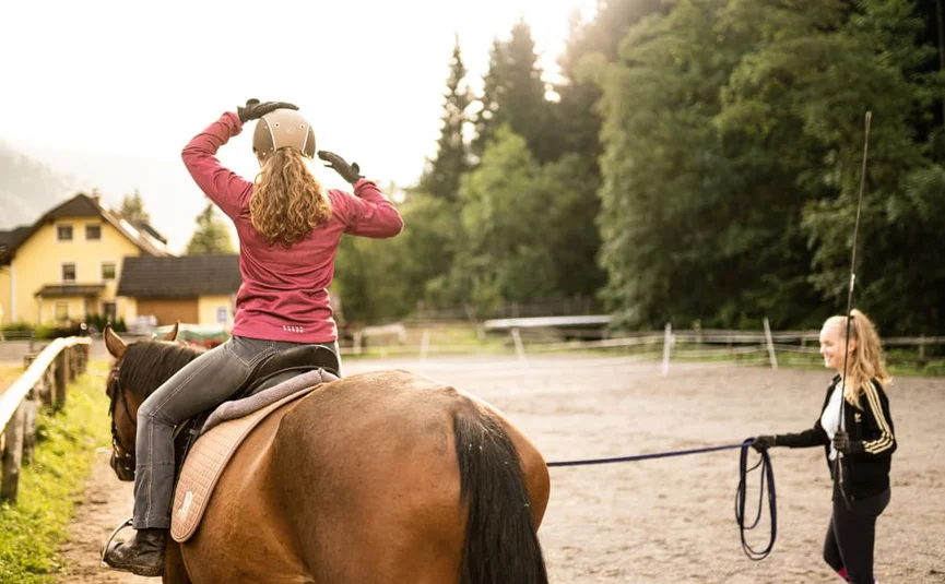 First happiness of riding / 3 nights Rider putting on helmet as trainer leads horse on a sunny day