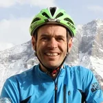 Mann in Fahrradhelm vor schneebedeckten Bergen