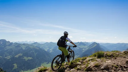 Mountainbiker op een pad met panoramisch uitzicht op bergen bij heldere lucht