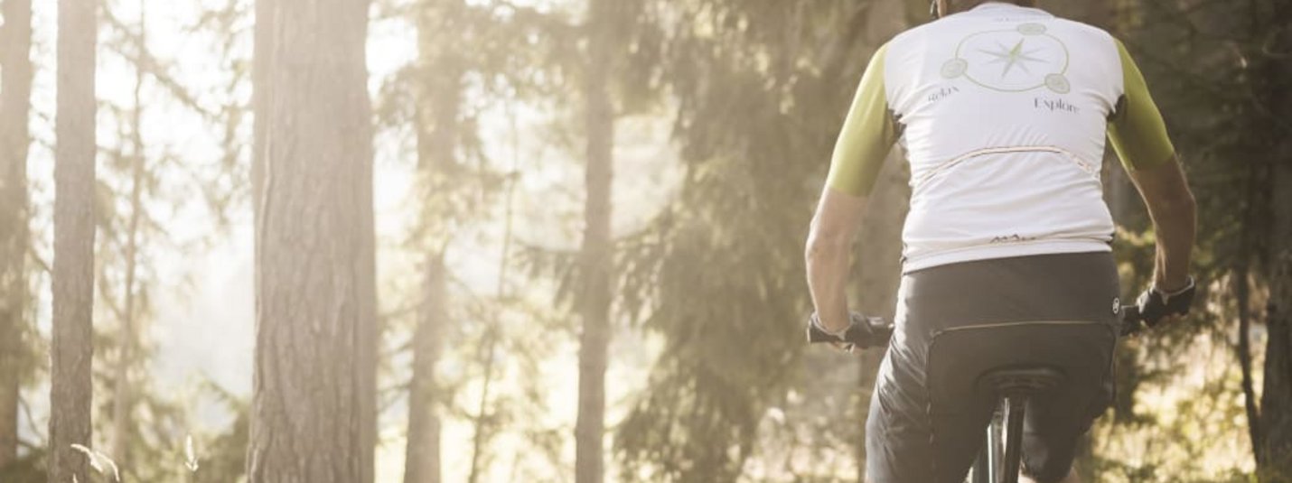 Fietser rijdt op bospaadje in zonlicht