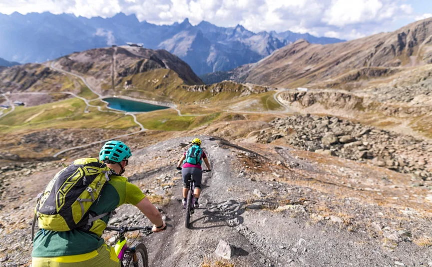Zwei Mountainbiker fahren einen steinigen Bergpfad in den Bergen entlang