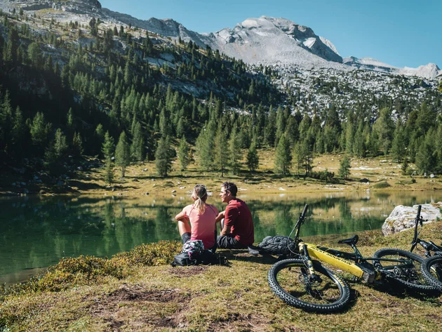 Ein Herbst-Wochenende in San Vigilio © Alex Moling Zwei Radfahrer sitzen am See in den Bergen und genießen die Aussicht