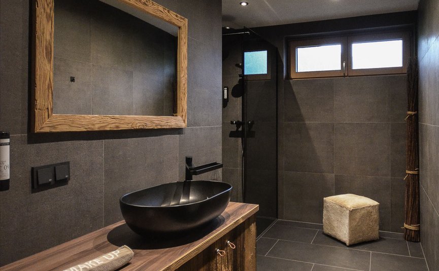 Modernes Badezimmer mit Holzwaschtisch und schwarzem Waschbecken