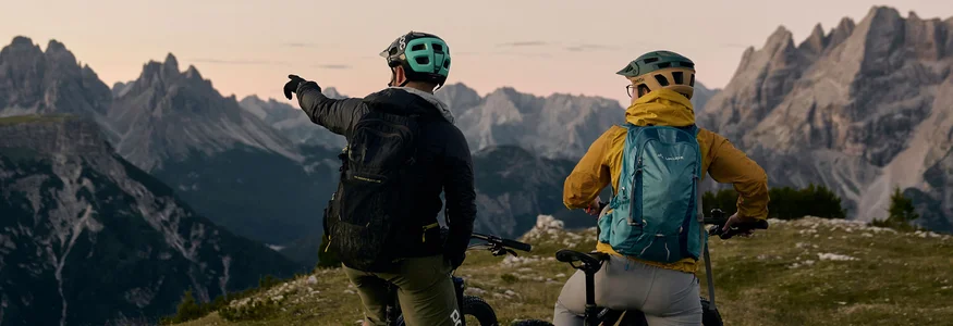 HIRBEN Naturlaub **** © David Rasche Two cyclists with helmets on mountain meadow looking at mountain peaks at sunset