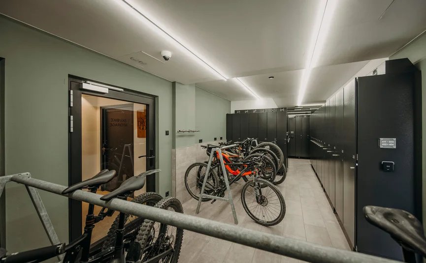 Modern bike storage room with mountain bikes and lockable lockers