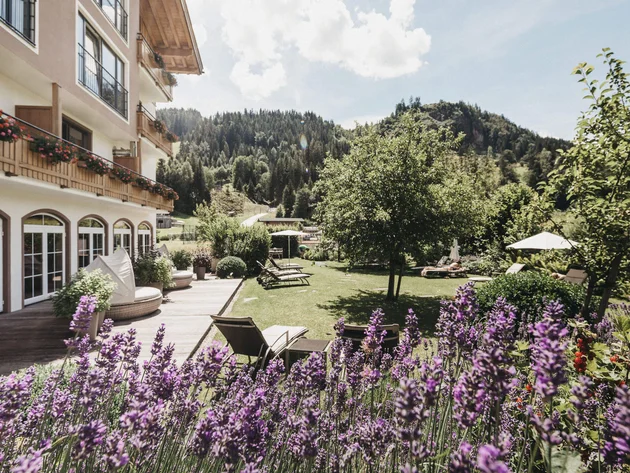 Was steckt hinter dem Umweltengagement von Bikehotels? © Biohotel Rupertus Hotelgarten mit Lavendel, Liegestühlen und Berglandschaft im Hintergrund