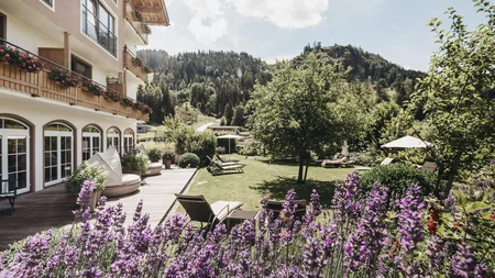 Was steckt hinter dem Umweltengagement von Bikehotels? © Biohotel Rupertus Hotelgarten mit Lavendel, Liegestühlen und Berglandschaft im Hintergrund