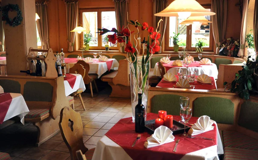 Gemütliches Restaurant mit rot-weißen Tischdecken und gedeckten Tischen